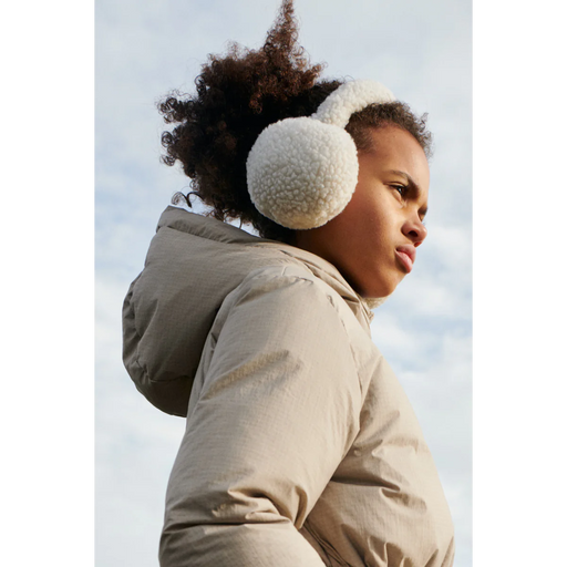 Young girl modelimg Albero Pile Earmuffs from Liewood Canada with puffer jacker with hands in pocket looking in the distance